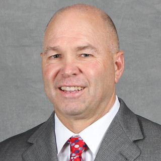 Randy Bennett wearing gray jacket, white shirt and red tie